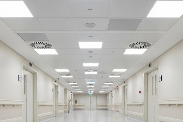 Corredor de clínica médica com forro de fibra mineral higiênico e placas resistentes a bactérias, garantindo segurança e limpeza extrema